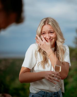 Candid moments of celebration with champagne against scenic overlook.