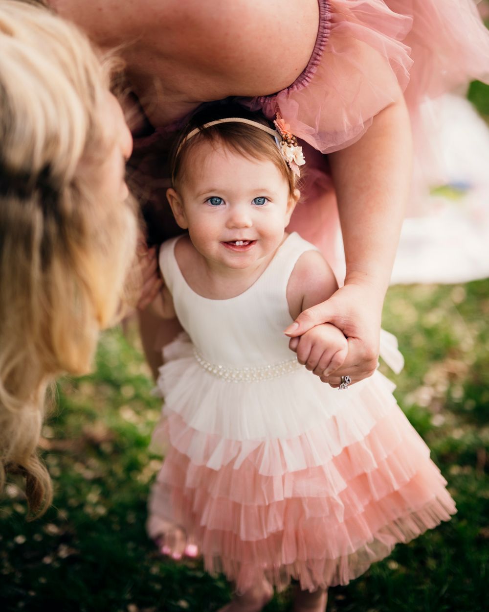 Sweet moment of a young child in a pink tulle dress smiling with joy.