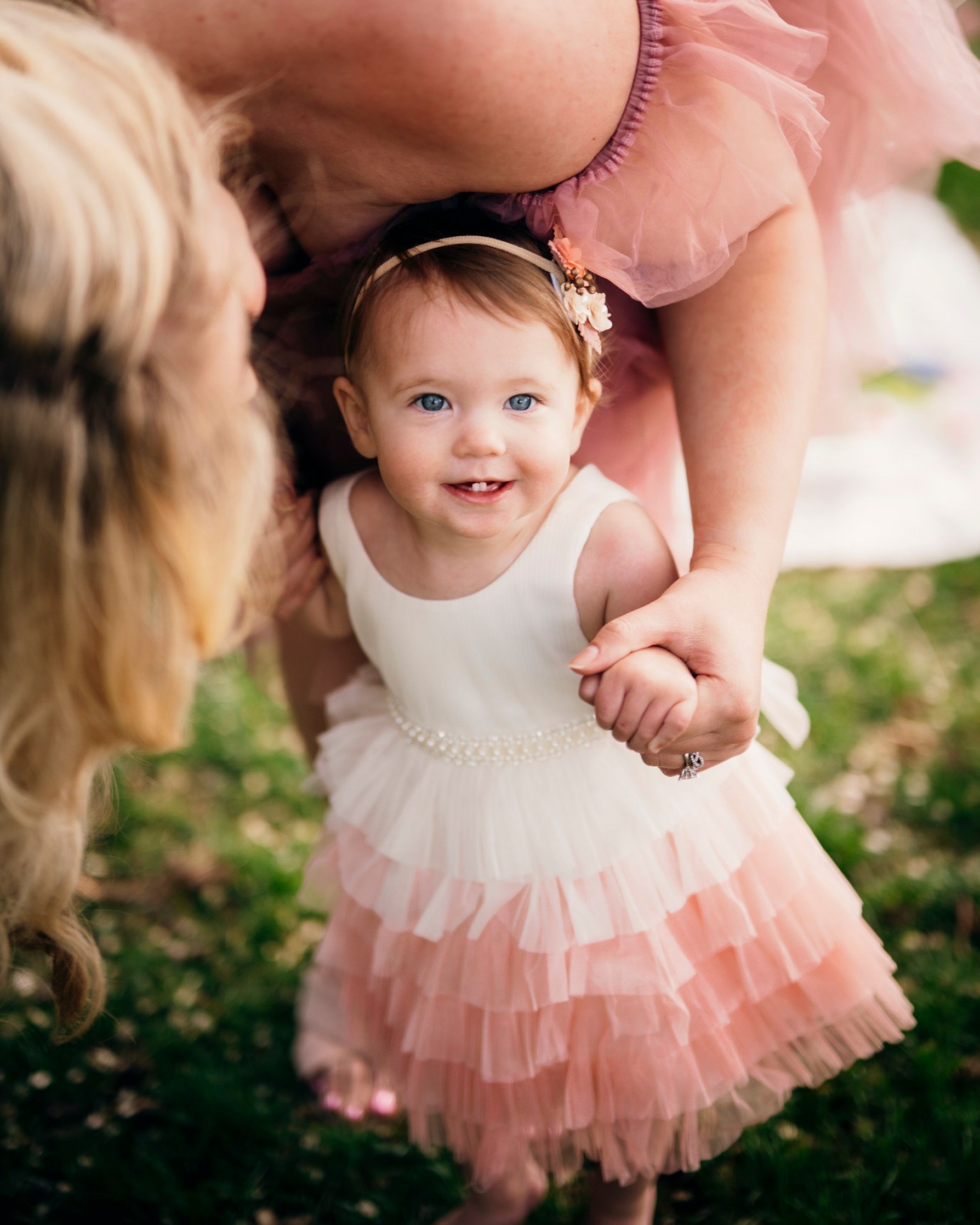 Sweet moment of a young child in a pink tulle dress smiling with joy.