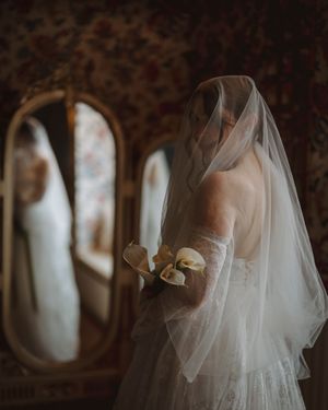 Flowing white wedding gown details shown in dramatic silhouettes against dark background.
