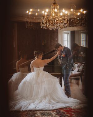 Elegant bride twirling in a flowing white wedding gown beneath crystal chandeliers.