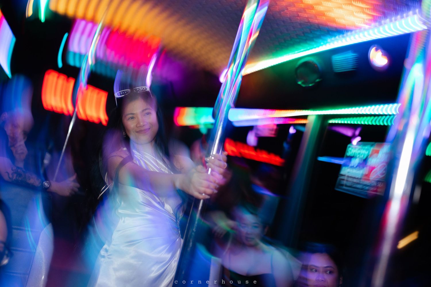 Colorful light trails and motion blur create an abstract nightclub scene with neon colors and dancing silhouettes.