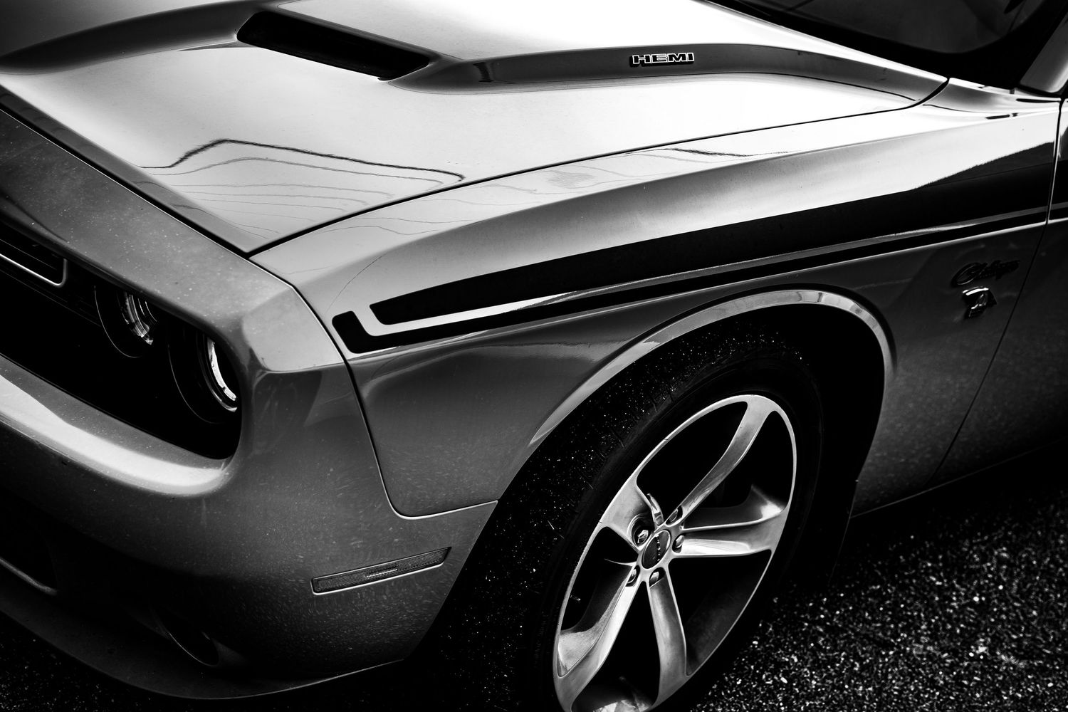 Black and white closeup photo of a sleek luxury car's exterior body panels and design details.