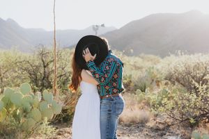 Dancing and laughing together in a scenic desert landscape.