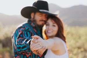 A romantic desert photoshoot featuring western attire and natural desert scenery.