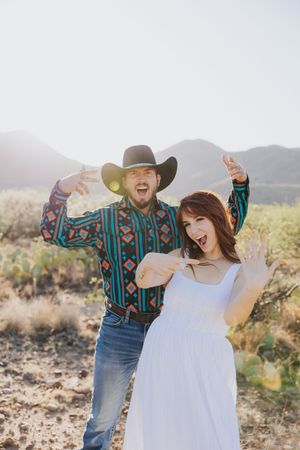 Dancing together in the desert sunlight wearing western-inspired outfits.