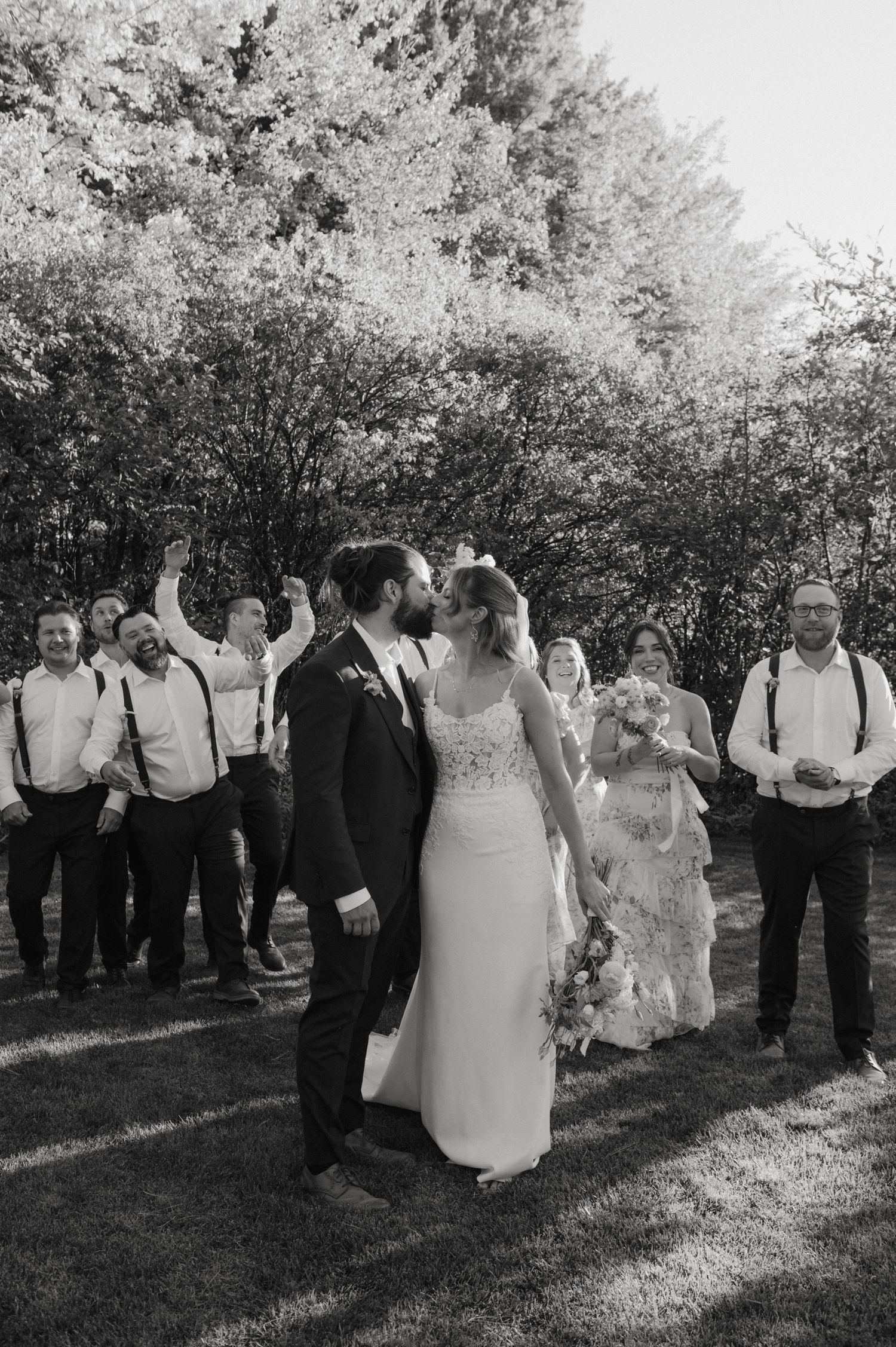 A celebratory moment during a wedding ceremony with guests seated on bistro chairs in an indoor venue.