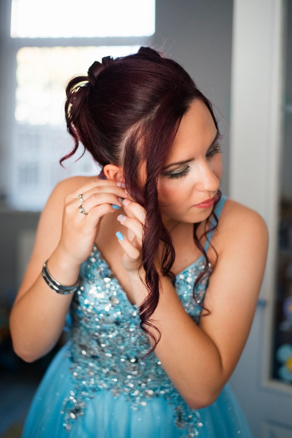 Detailed shot of formal hairstyle and sparkly blue formal dress.