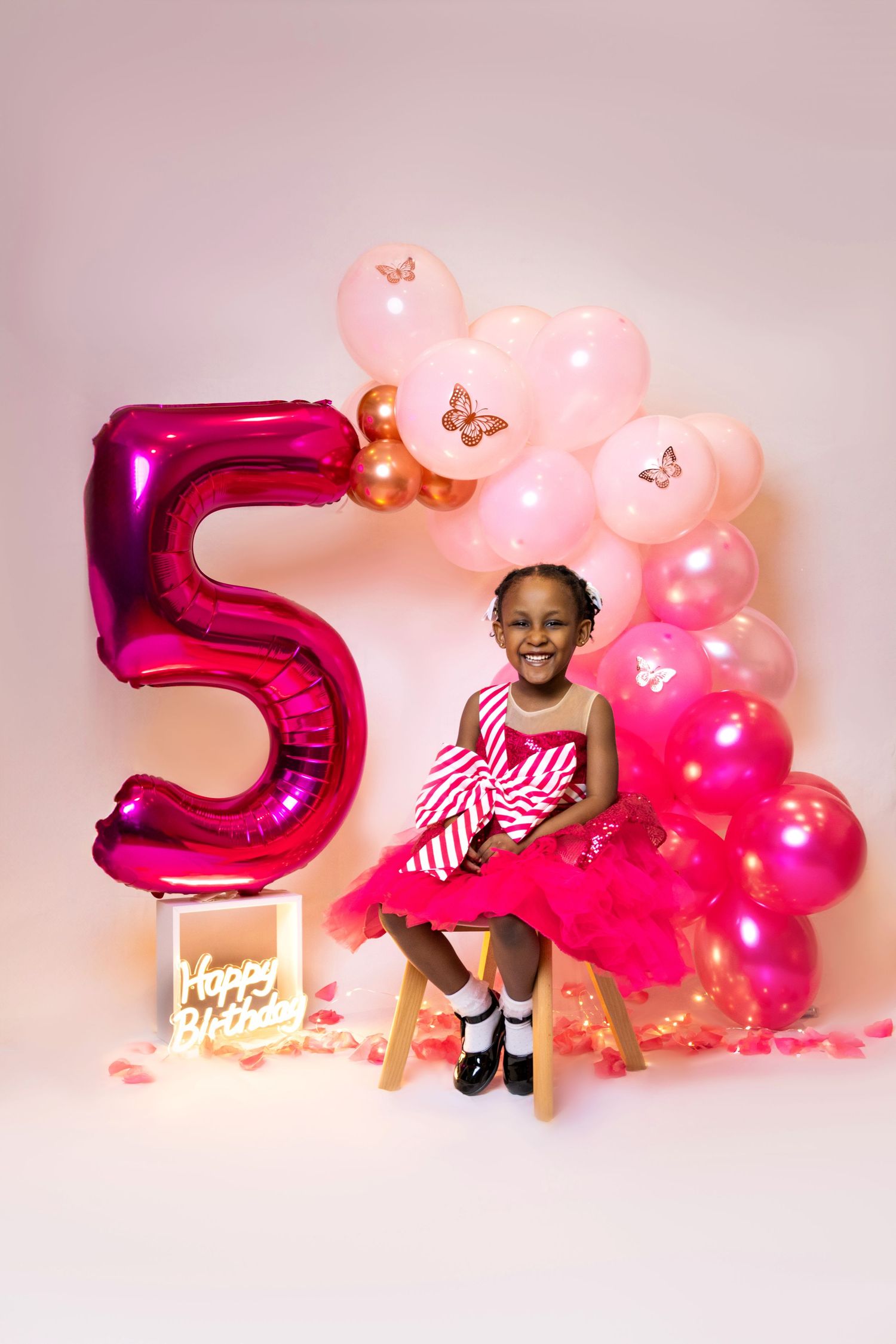 Pink and magenta balloon decorations with a large number 5 create a festive birthday setup.
