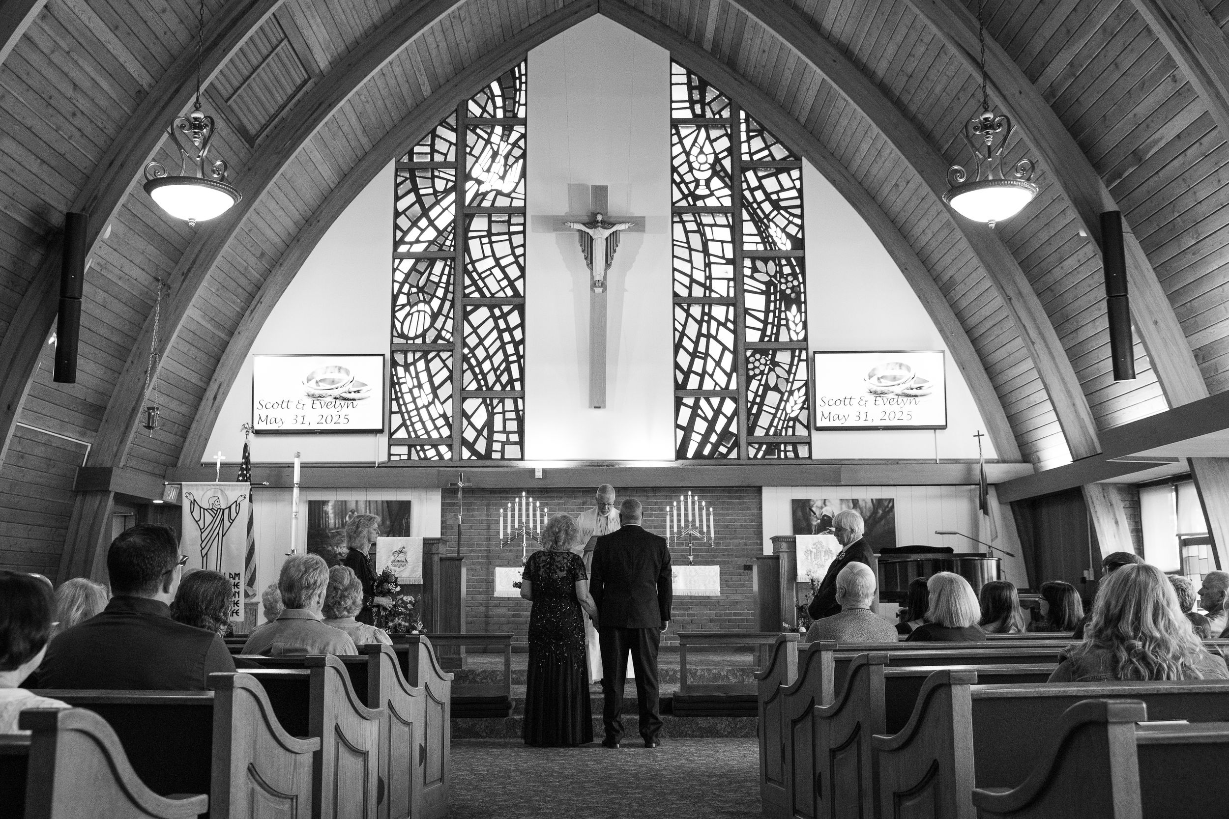 People gather in a modern church interior with wooden beams and contemporary architectural features.