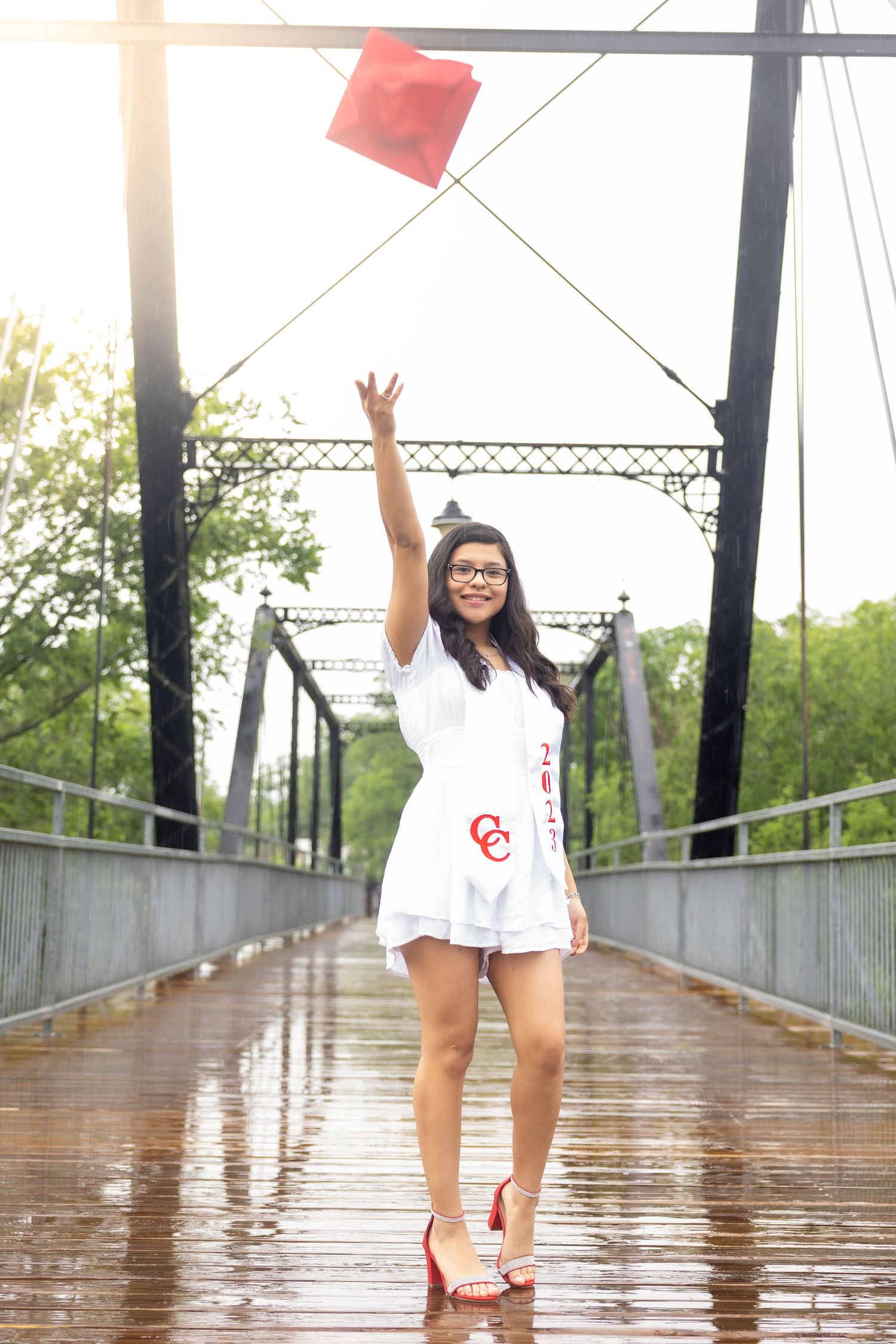 A sequence of joyful moments captured on a wet wooden bridge walkway with red and white attire.