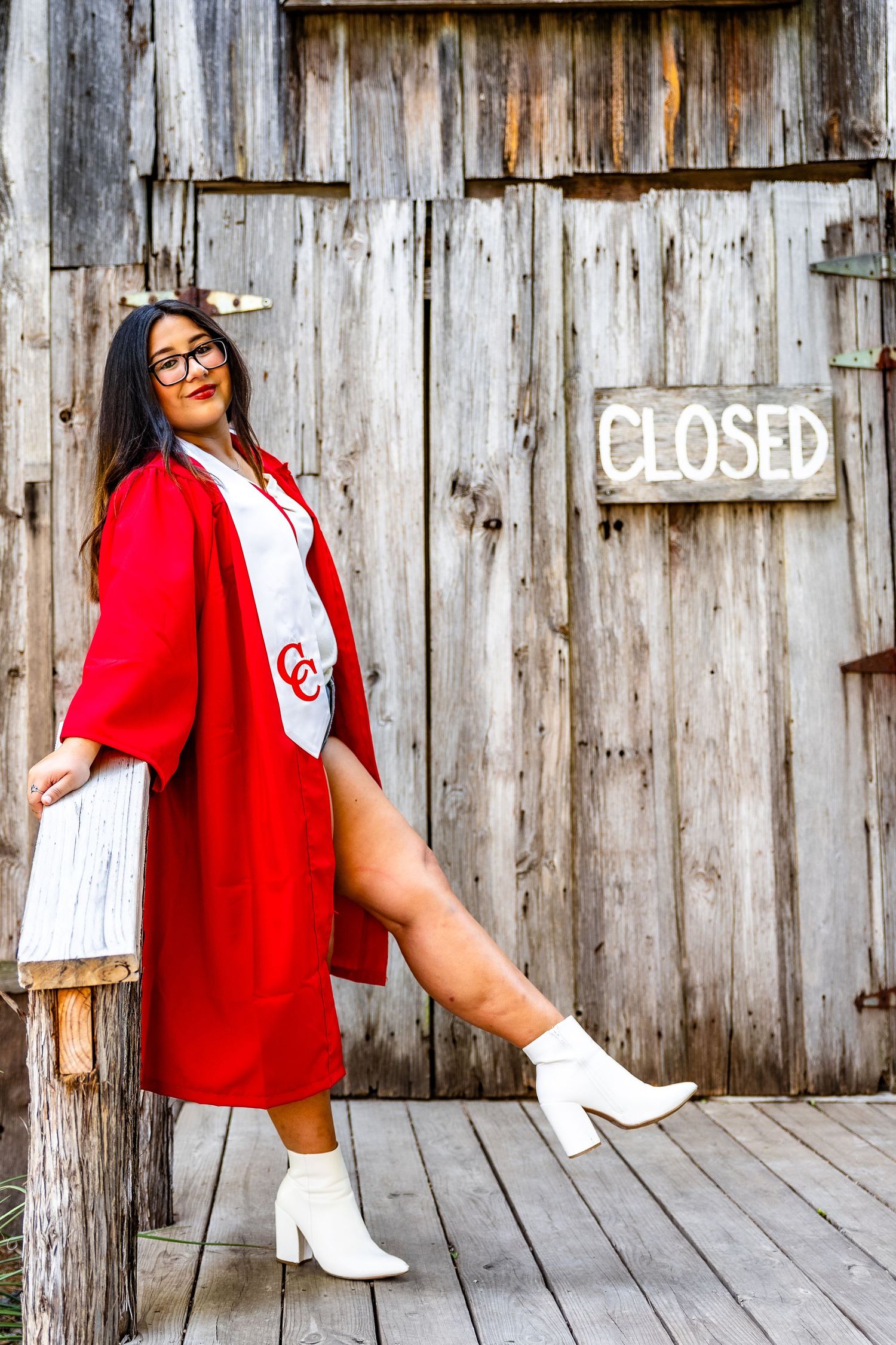 Retro-style fashion photo against rustic wooden wall featuring red and white outfit with white boots.