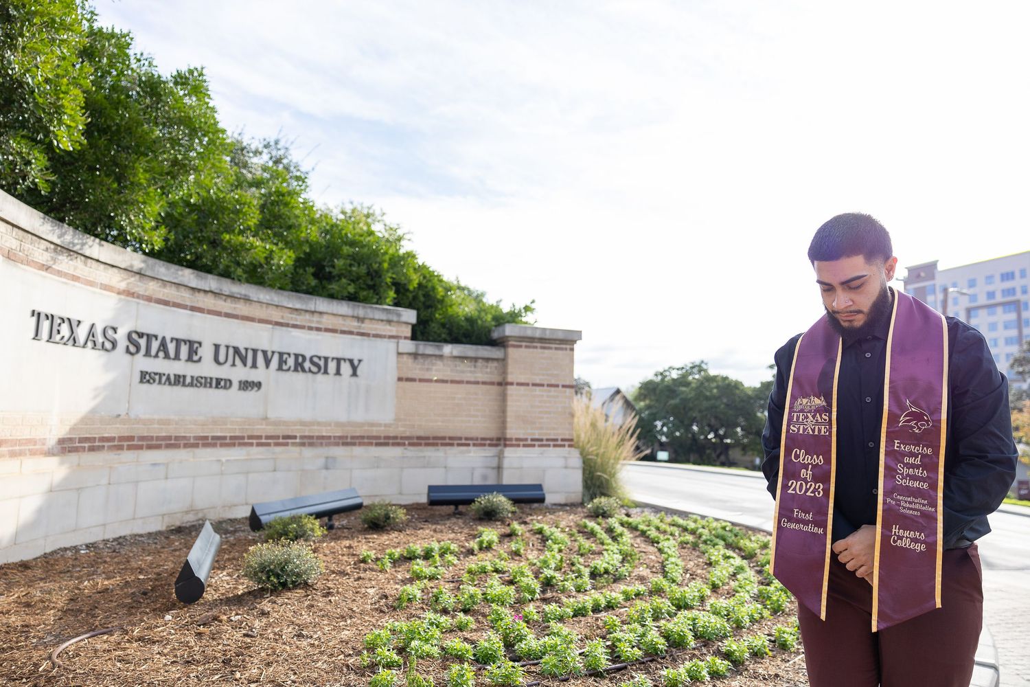 Rooftop garden with rows of vegetables and herbs growing in raised beds at Texas State University campus.