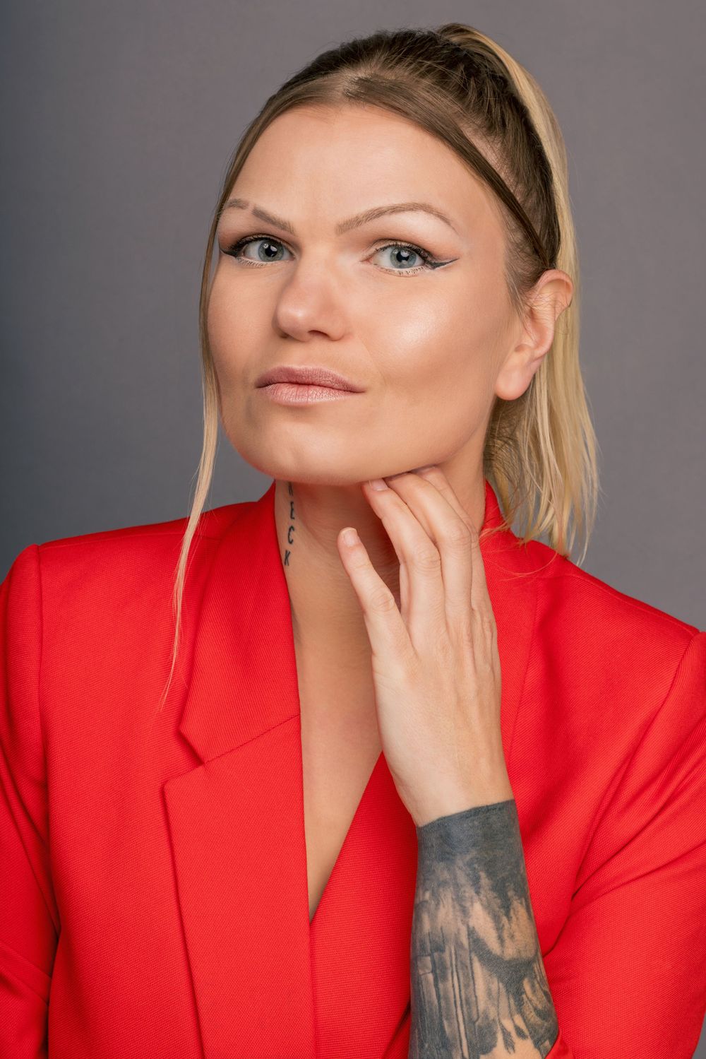 Fashion portraits in bright red blazer showing confident poses against grey backdrop.