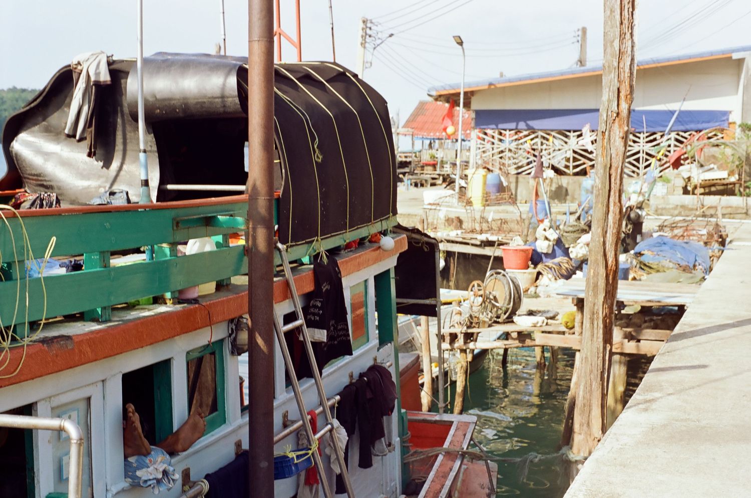 Row of fishing boats and equipment docked at a marina with wooden piers.