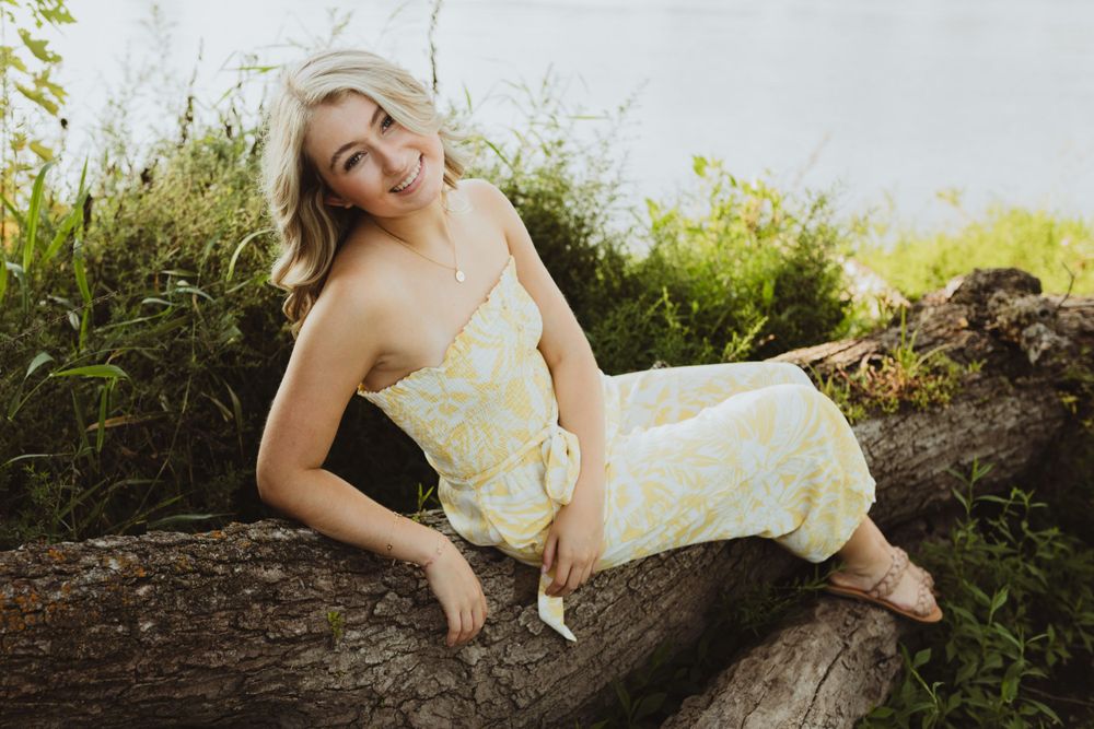 Artistic outdoor portrait session featuring a yellow dress against natural scenery.