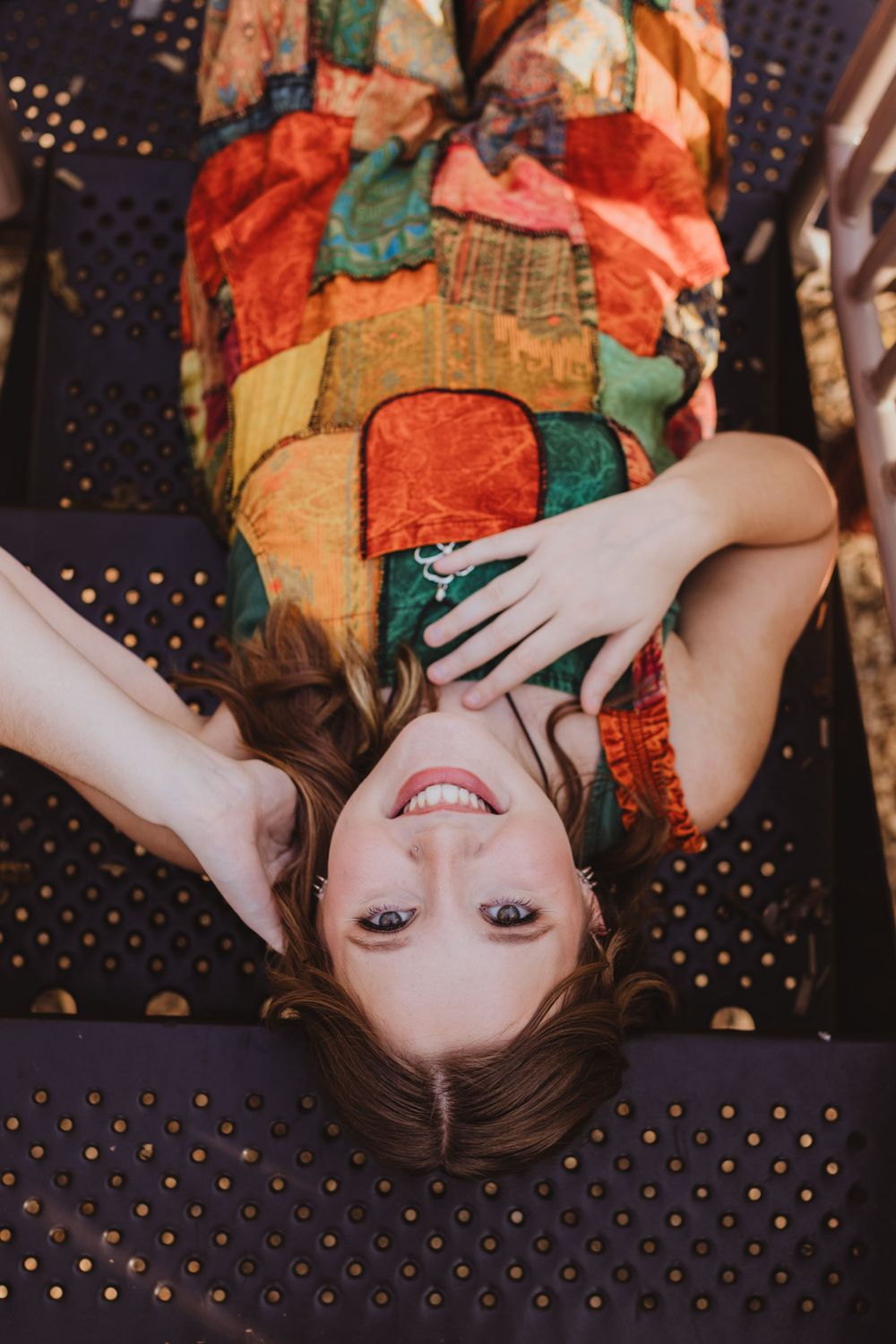 Creative portrait on dark background with colorful patterned fabric and gold dots.
