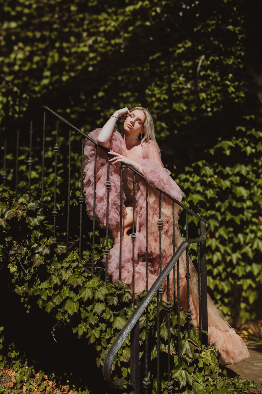 Artistic wedding photoshoot through iron gates with greenery and soft lighting.