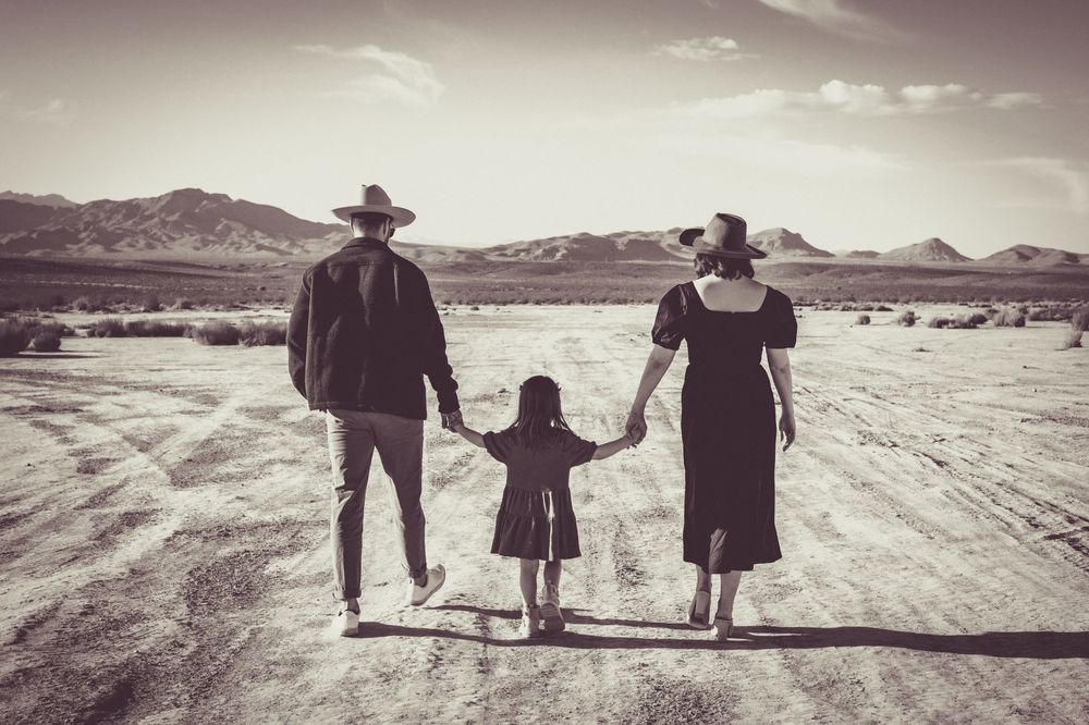 Family walking hand in hand across desert landscape of dry lake bed. Family photography in Las Vegas. Family photographer Las Vegas.
