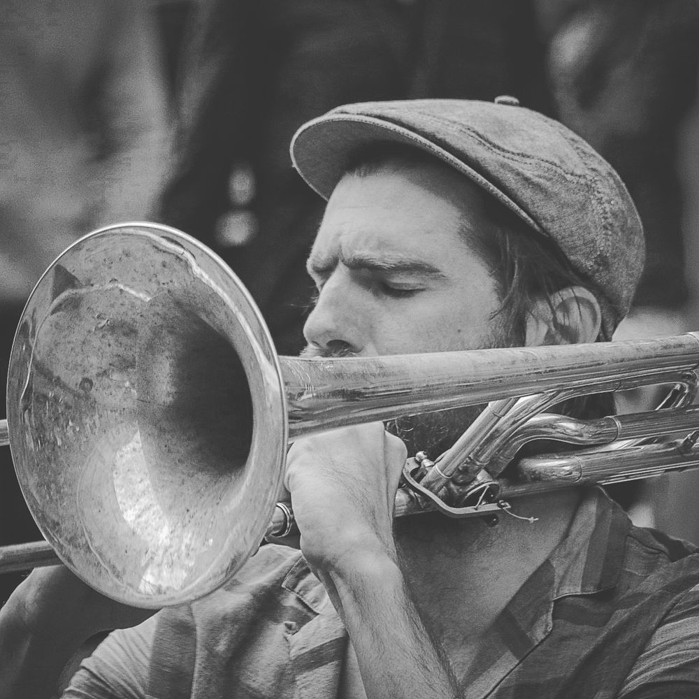 Musicians playing brass instruments in black and white vintage style photography.