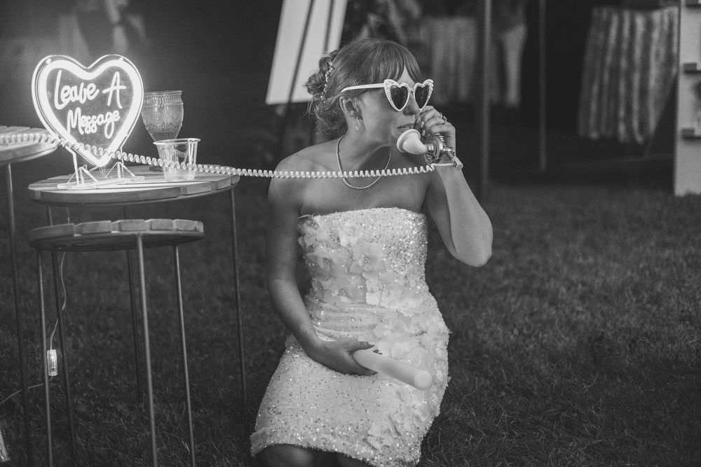 Black and white photo of wedding reception dancing with decorative lights.