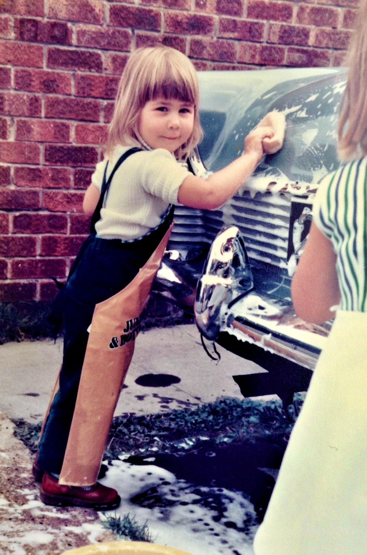 Photo of Ellie McCallum photographer as a child washing the car. Newcastle.