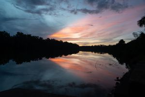 Coucher de soleil se reflétant sur un fleuve en Guyane