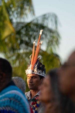 Homme portant une coiffe de plumes traditionnelle en Guyane