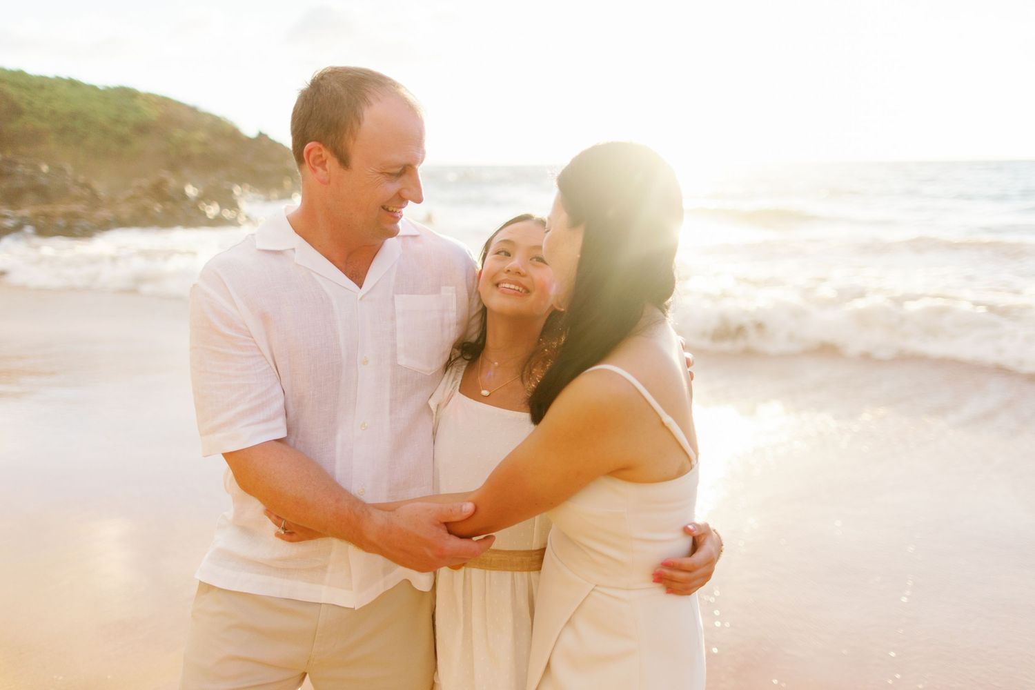 Family walking together on wooden boardwalk surrounded by lush greenery.