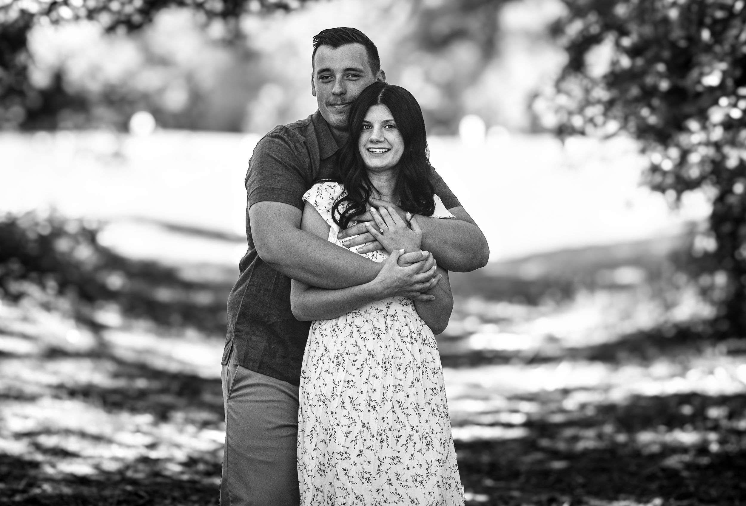 Natural light engagement photos of couple in a wooded setting.