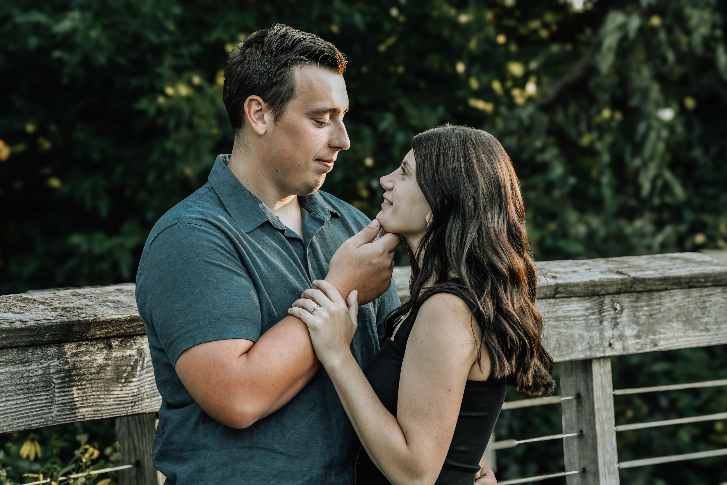 Dancing couple share tender moments on a wooden deck during a romantic photoshoot.