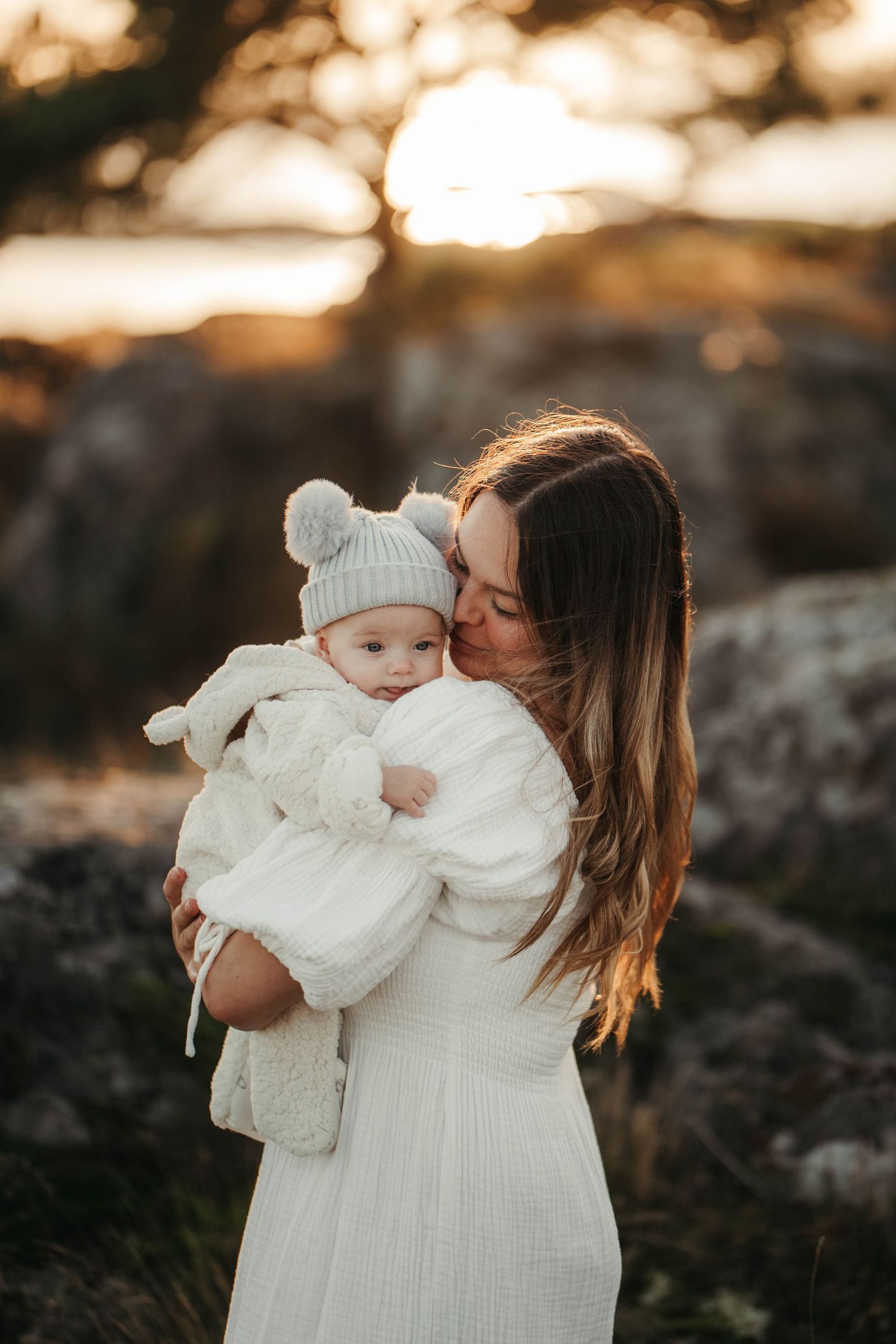 Mamma med sin bebis i famnen på klipporna i Nynäshamn