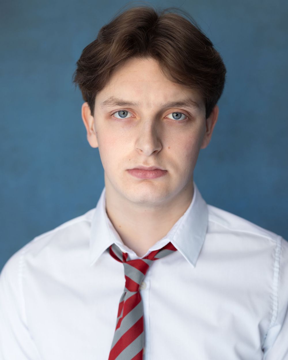 Young male student actor headshot wearing school uniform with striped tie for drama portfolio