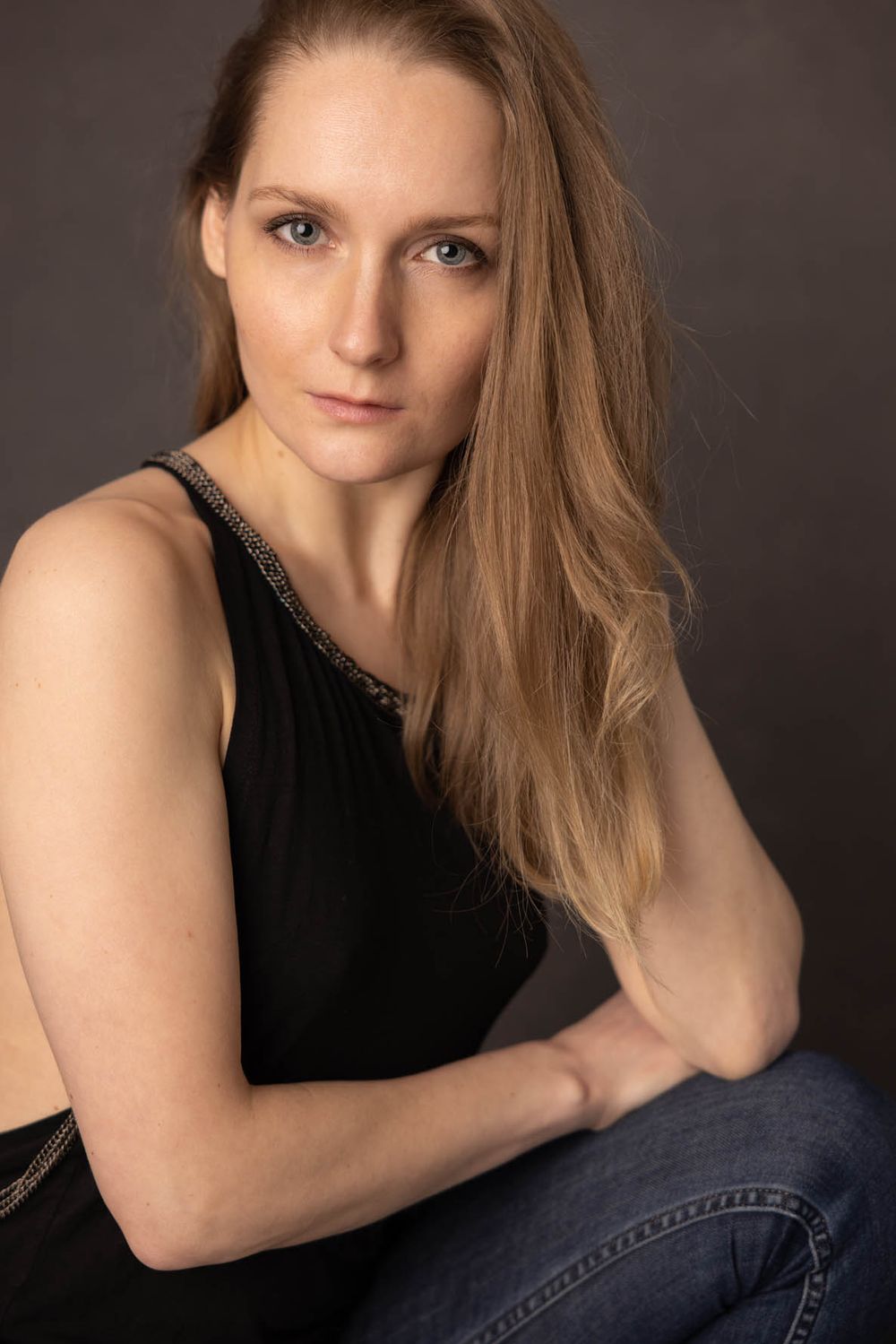 Professional actress headshot with blonde hair wearing black sleeveless top for dramatic portfolio photography