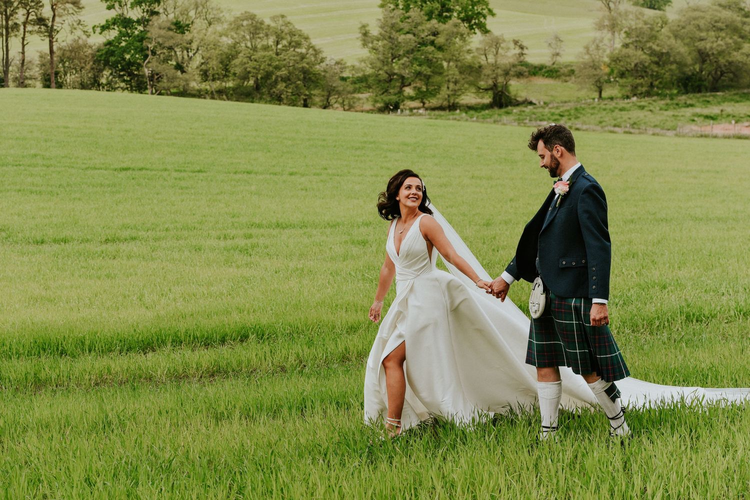 Wedding portrait at sunset with glowing orange light walking through fields Enterkine House Ayrshire