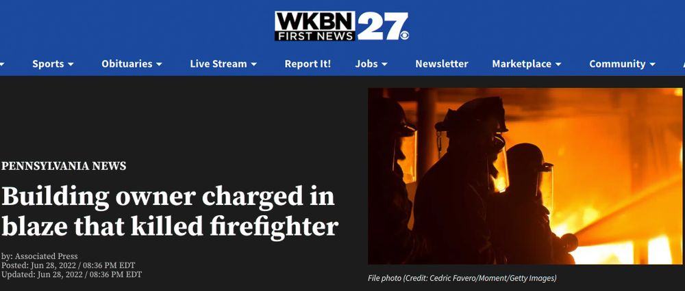 News article headline about a building owner charged in a deadly fire that killed a firefighter, with flames visible in background.