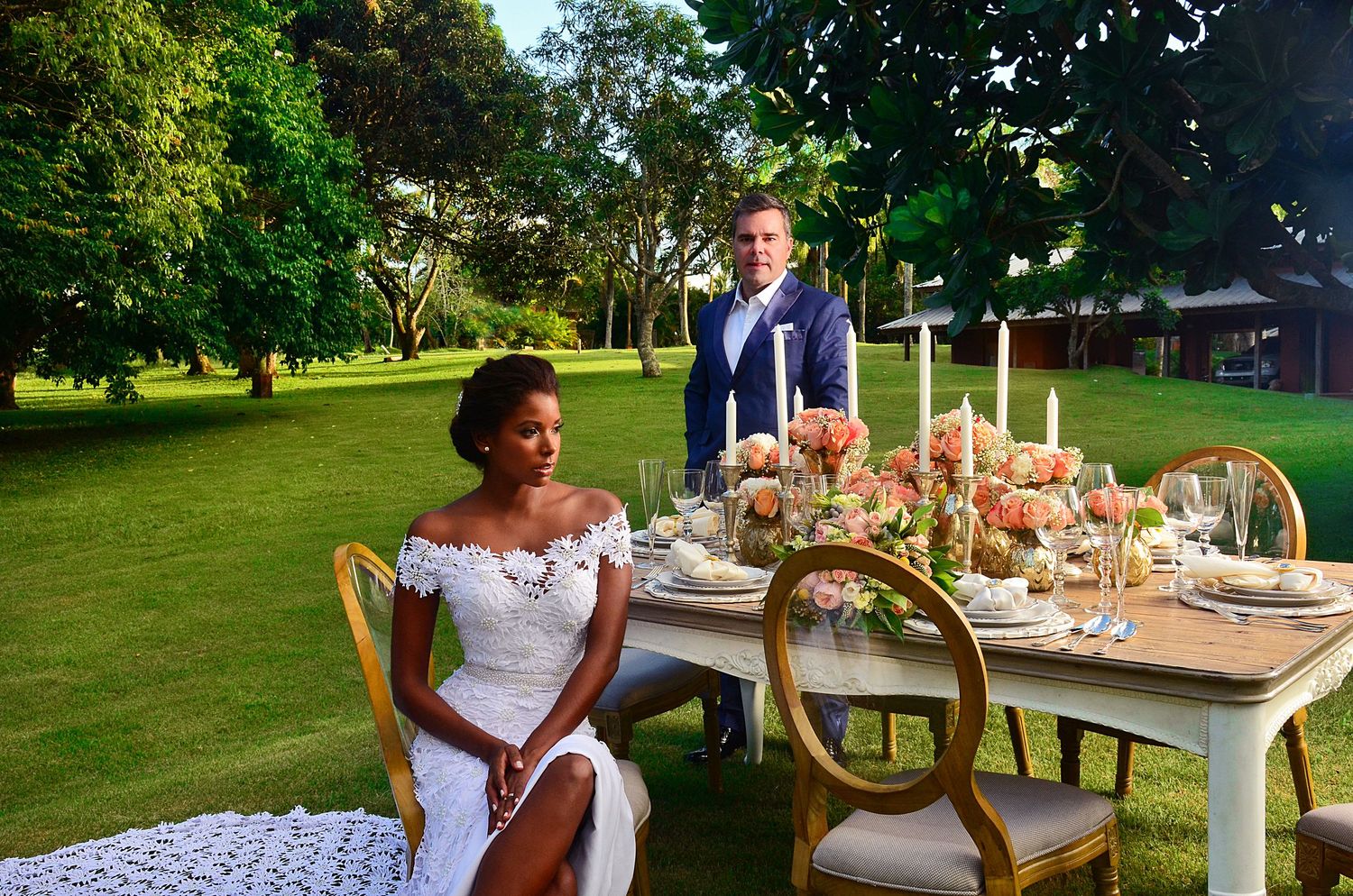 Romantic outdoor wedding reception table setting with elegant decor in a garden setting.
