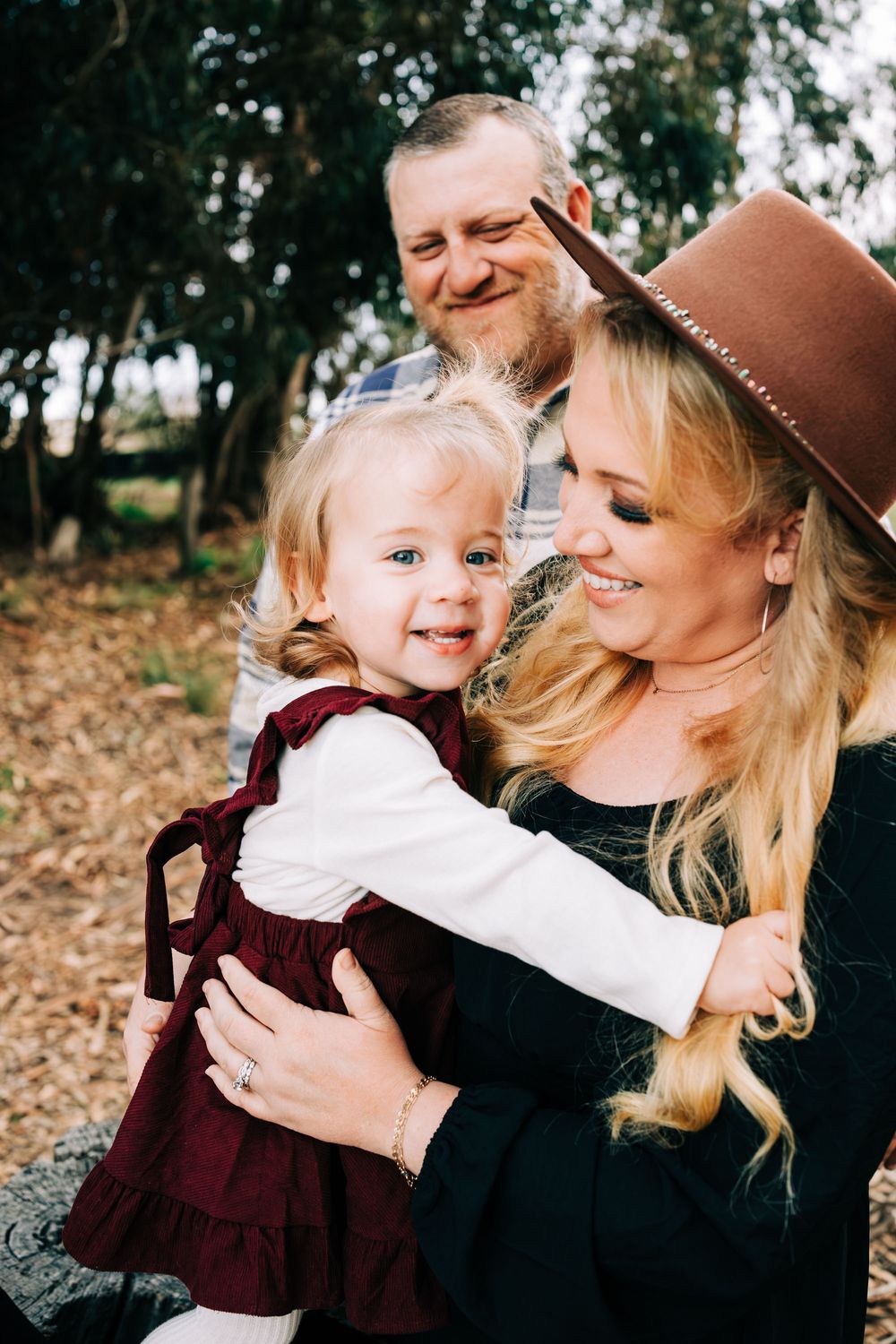 Family session in Santa Maria, CA. Baby looking at me, mom looking at baby, dad looking at them both from behind.