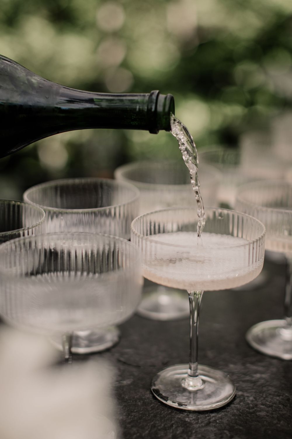 Crystal champagne glasses on a dark surface with bokeh background create an elegant setting for celebration.