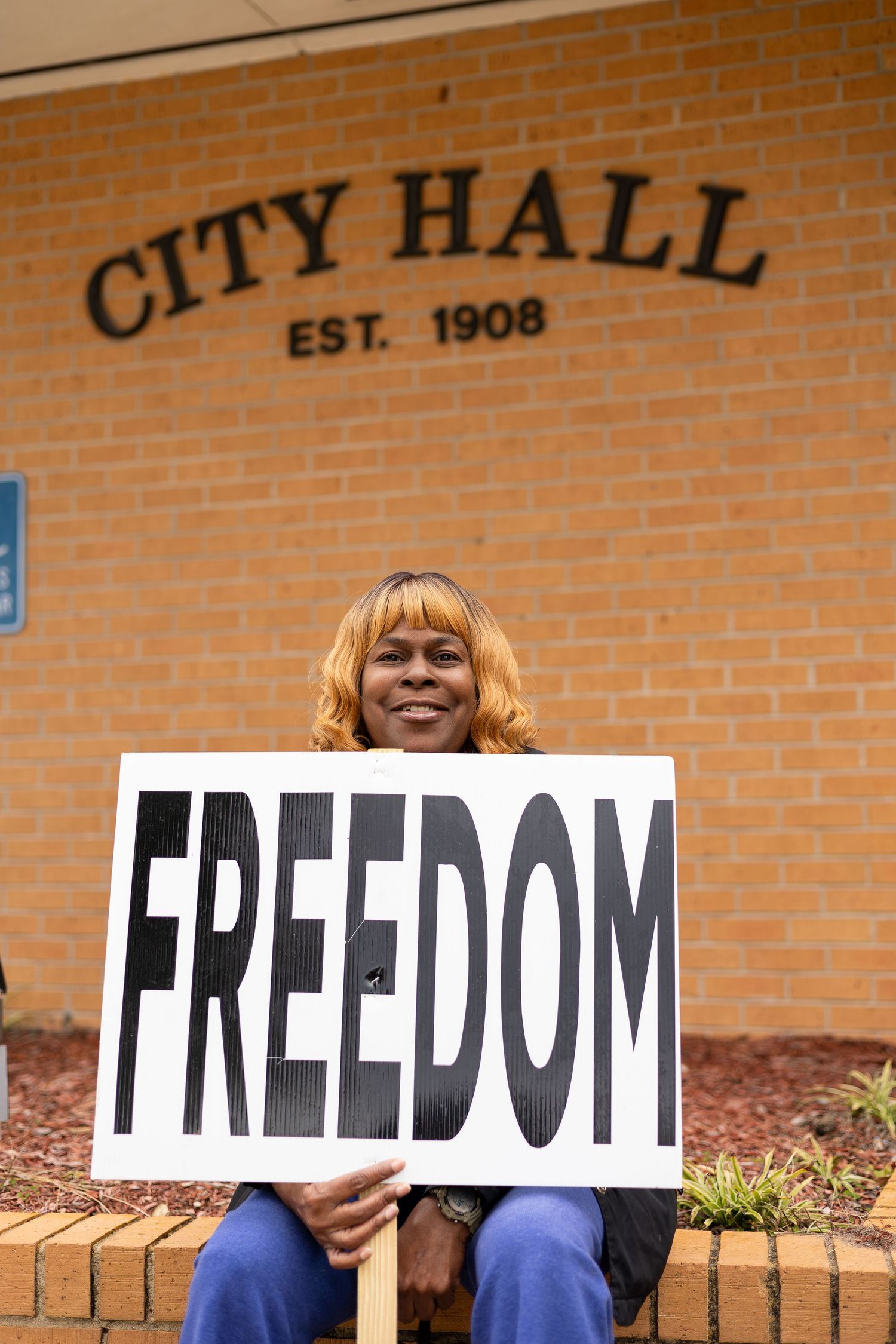 Sign reading FREEDOM held outside City Hall established in 1908.