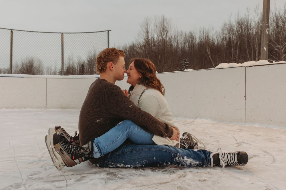 Couple sitting intimately on an ice rink during a winter date.