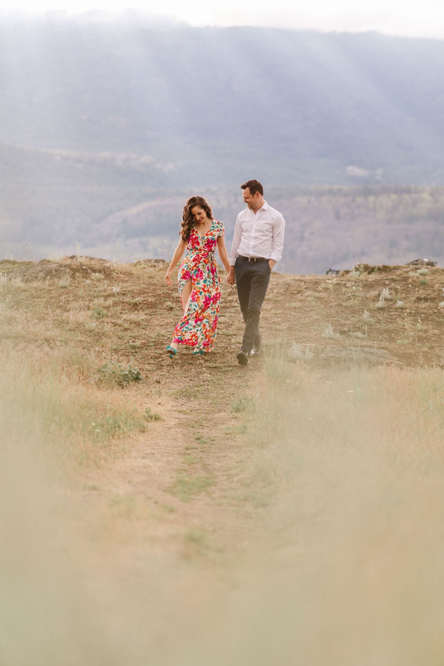 Romantic couple walking and twirling on a scenic mountain overlook.