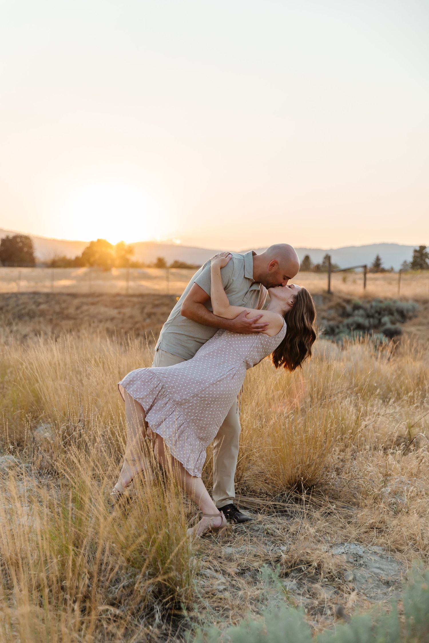 Couple sharing intimate moment in golden wheat field at sunset.