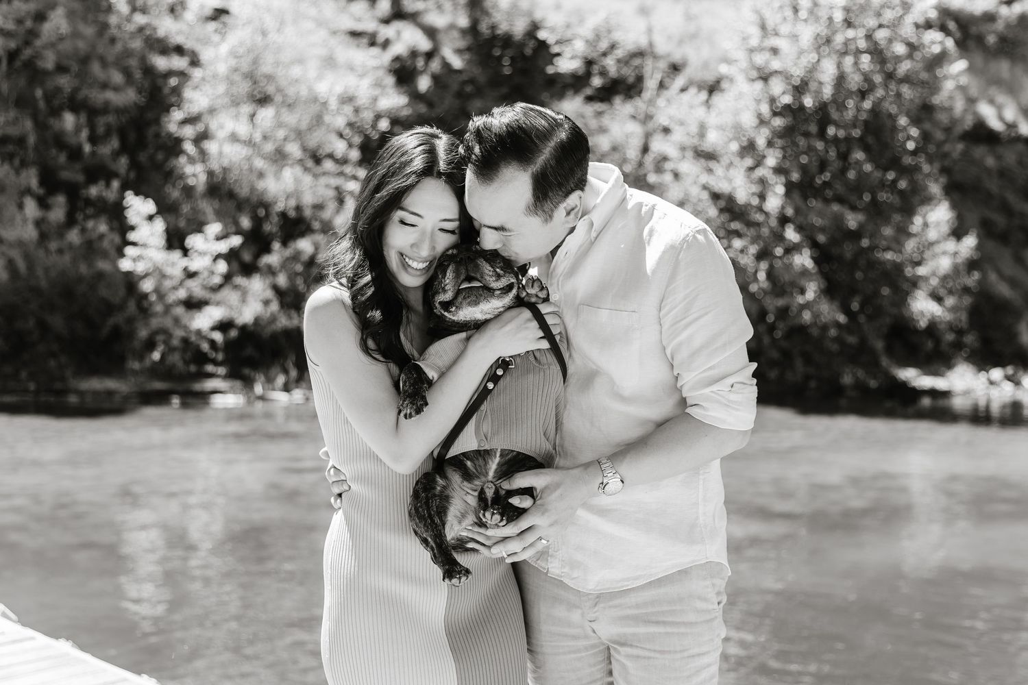 A couple shares intimate moments in a garden setting during a romantic black and white photo session.