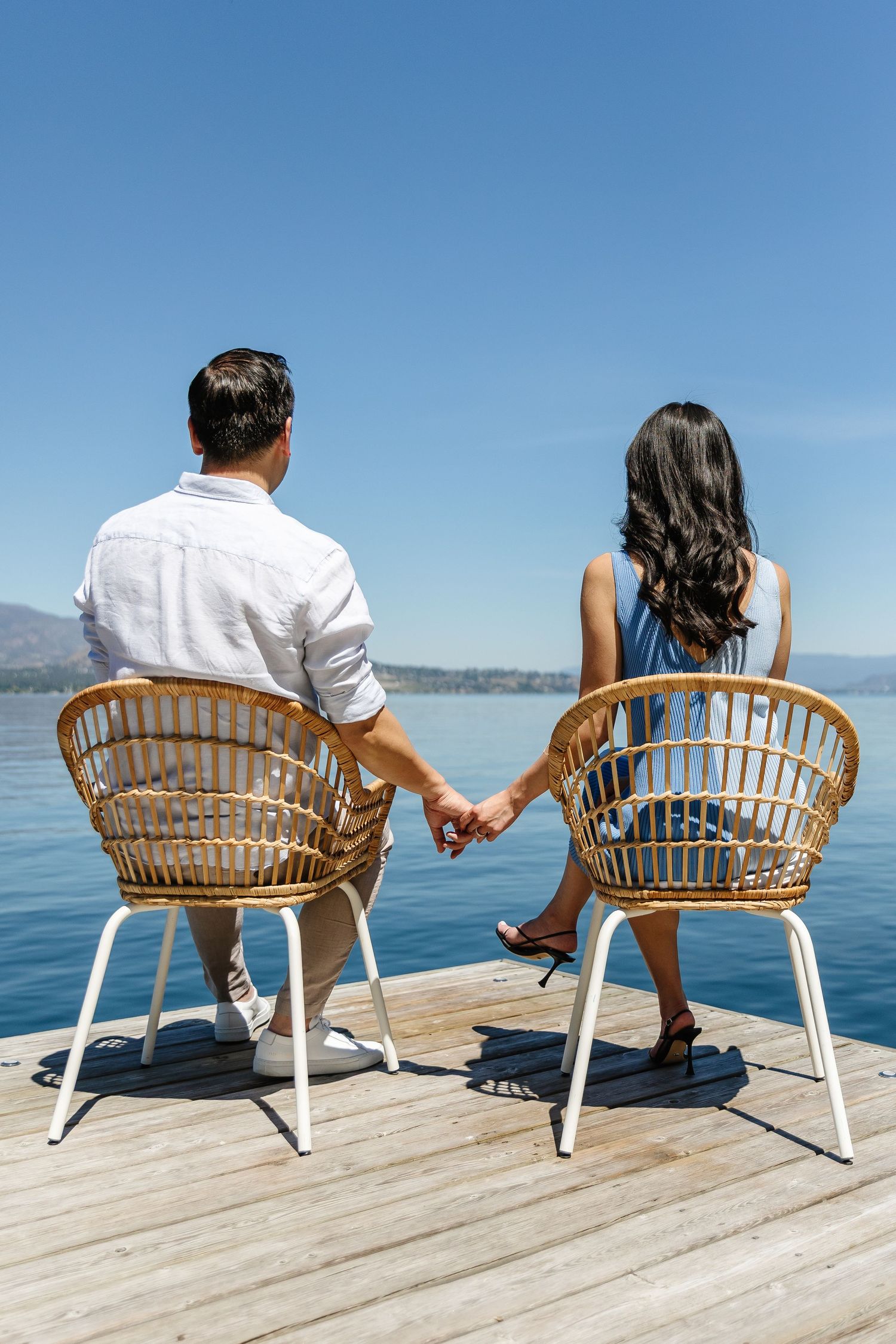 Series of photos showing couple sitting in white chairs on wooden dock by calm blue water.