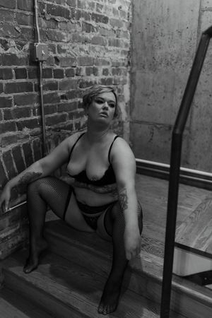 adult person posing on stairs, wearing lingerie, during a boudoir photography session