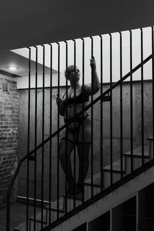 adult person posing on stairs, wearing lingerie, during a boudoir photography session