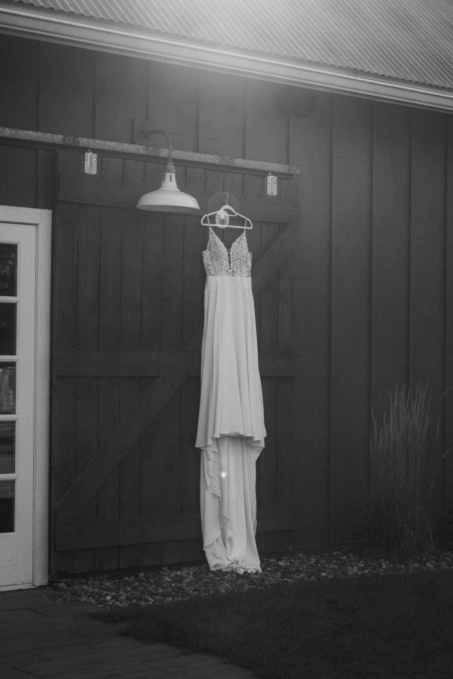 wedding dress hanging on a barn door at a wedding venue in Minnesota