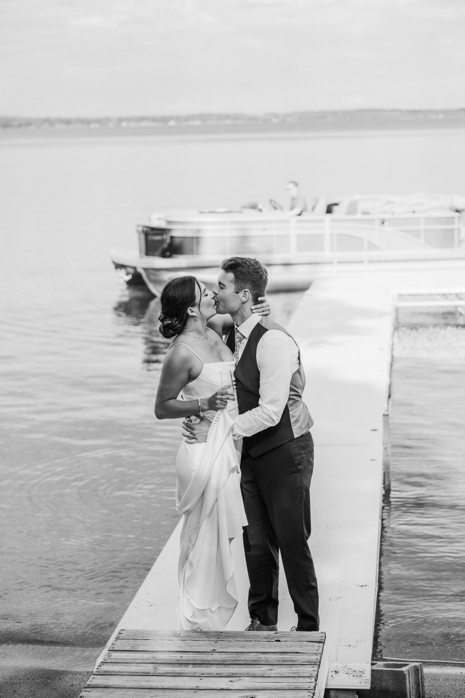 bride and groom kissing on the dock after there wedding ceremony.