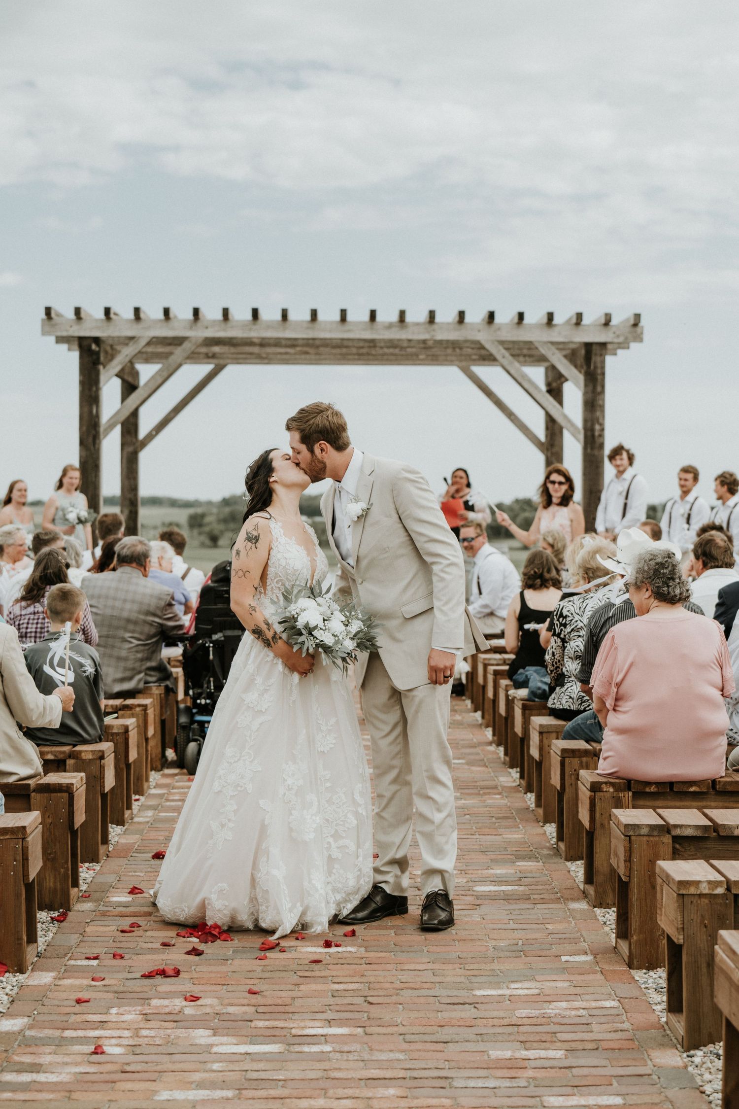 Stone Hill Farm Eagle Bend MN. Couple share a kiss down the aisle after they were married.